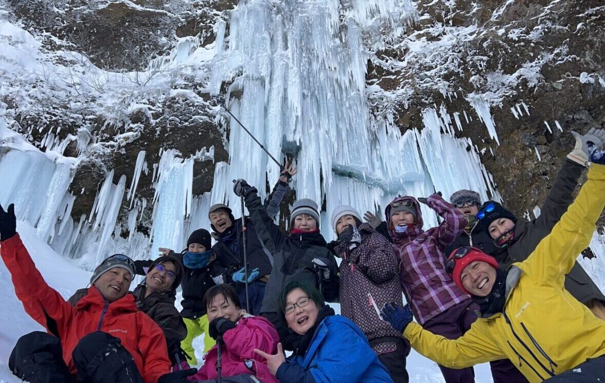 巨大な氷瀑がある仙人沢アイスガーデンの目の前でツアーのみんなと写真撮影