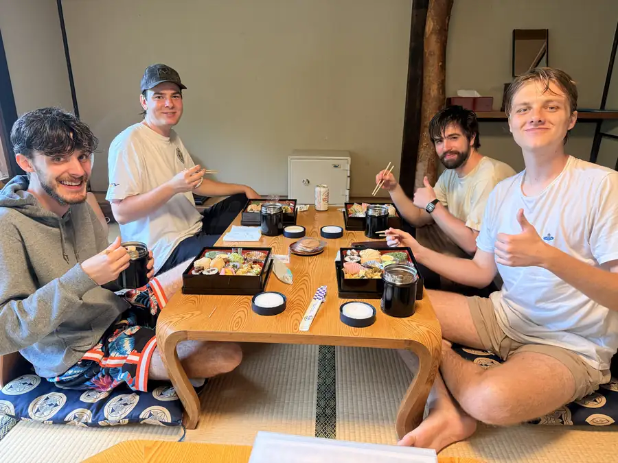 Four travelers share a bento lunch at the inn