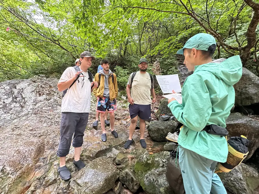A guide briefs travelers beside the river